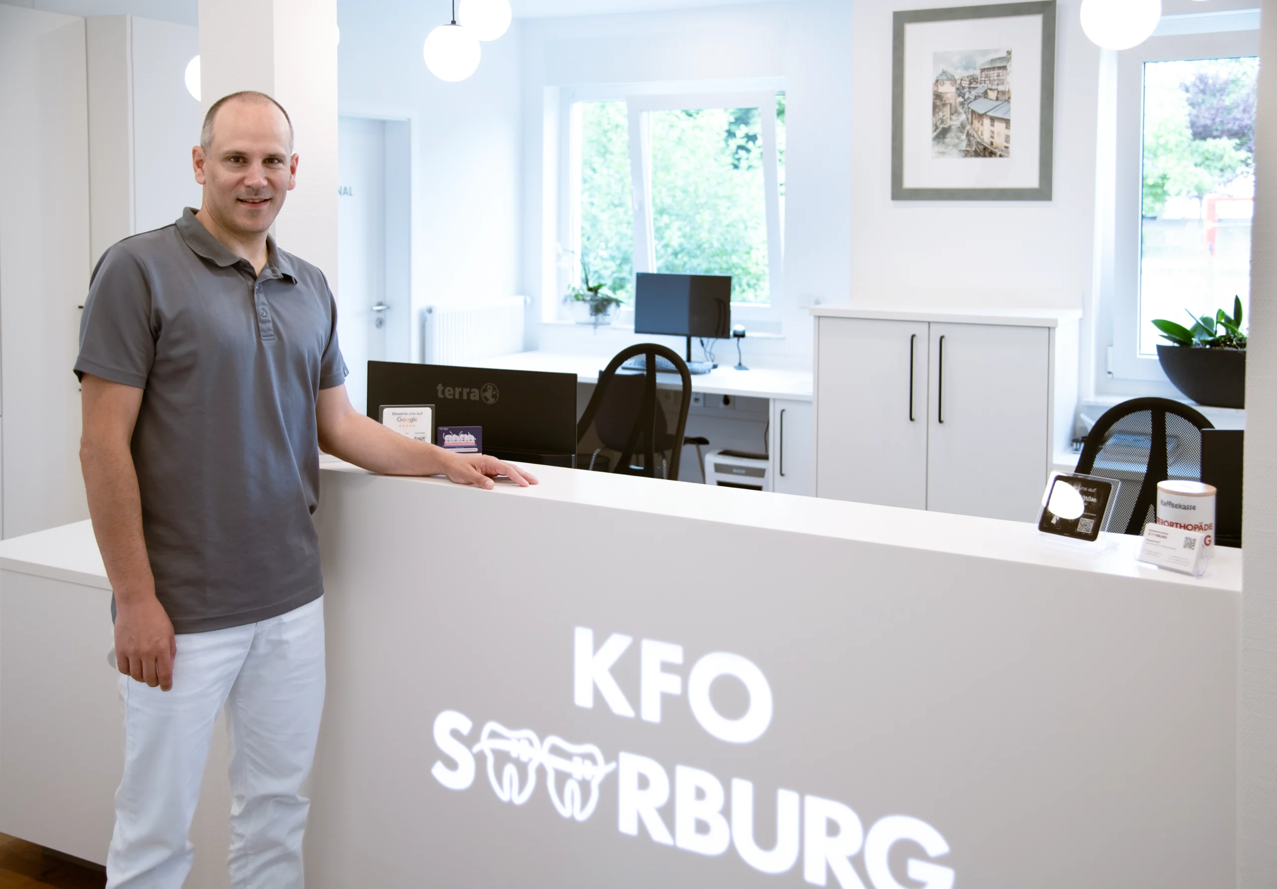 Fachzahnarzt Dominik Keil an der Rezeption der Kieferorthopädie Saarburg.