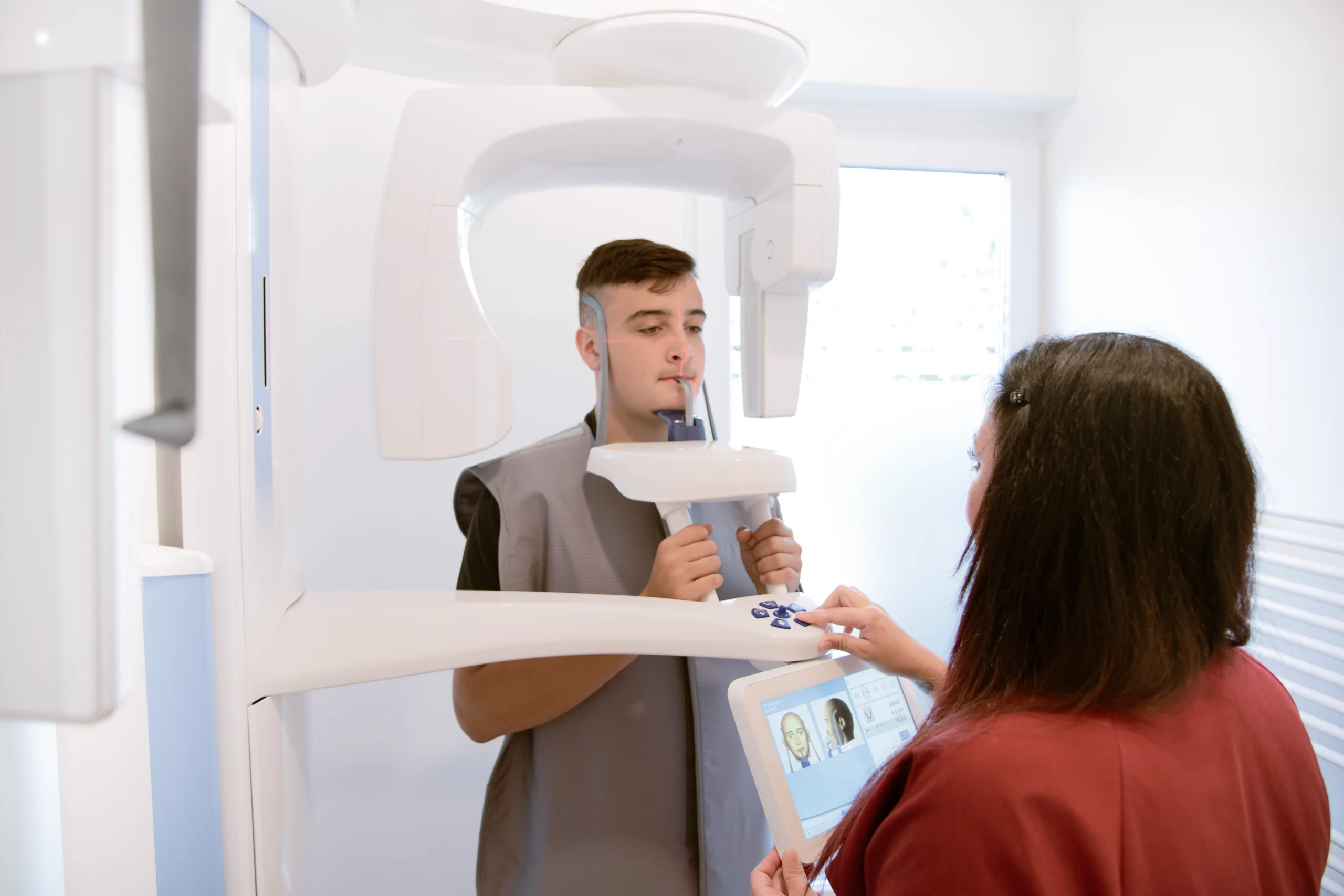 Jugendlicher bei einer kieferorthopädischen Röntgenuntersuchung mit digitalem Röntgengerät.