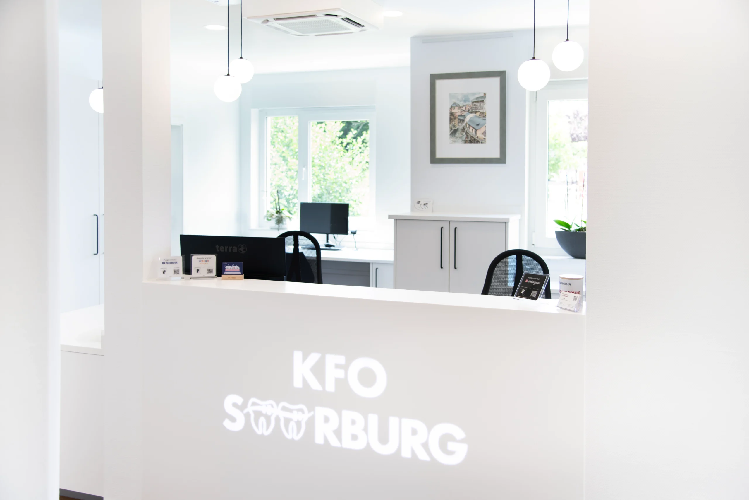 Heller Empfangsbereich der kieferorthopädischen Praxis KFO Saarburg mit modernem Empfangstresen.