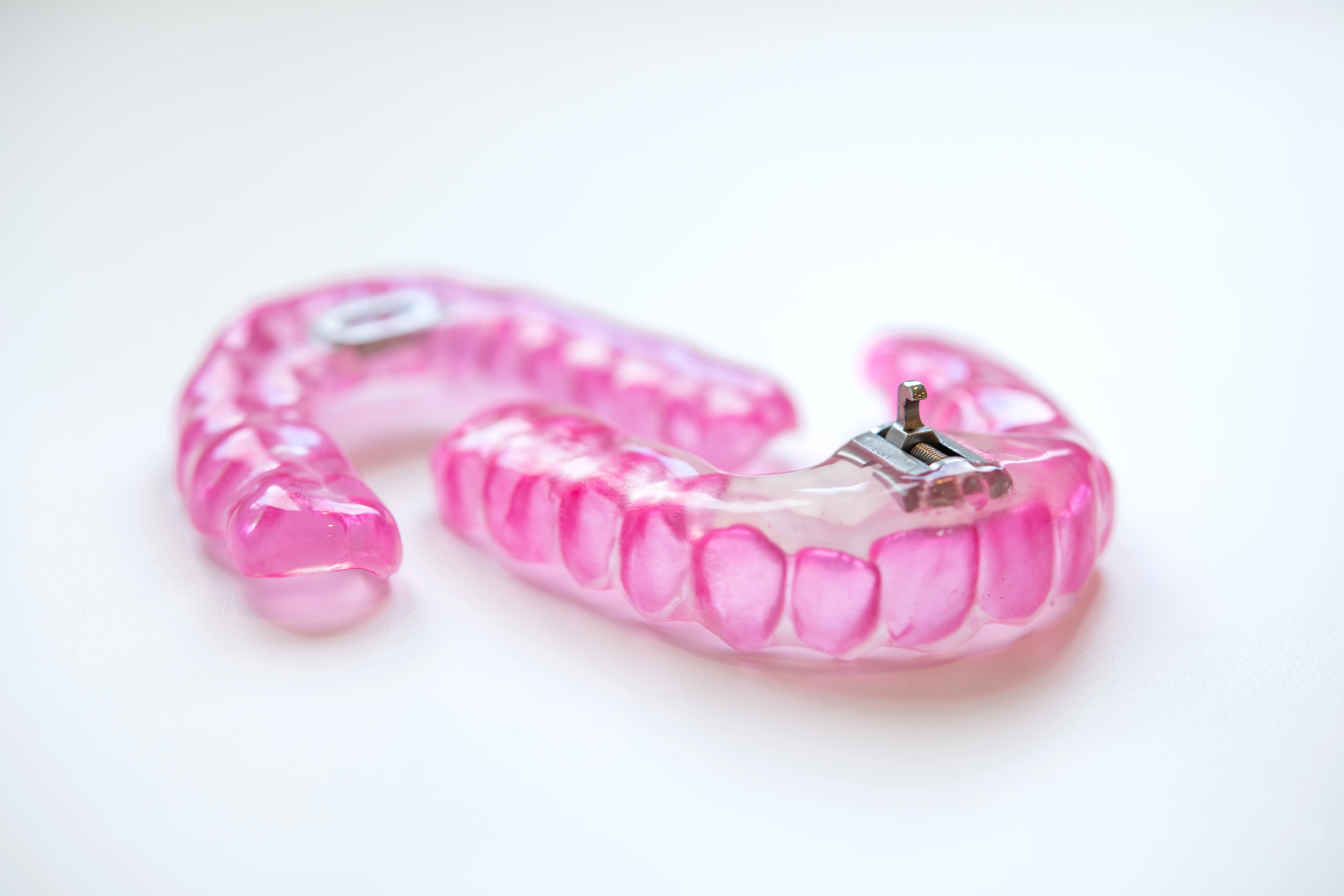 Pinkfarbene Schnarcherschiene zur Behandlung von Schnarchen und Schlafapnoe.